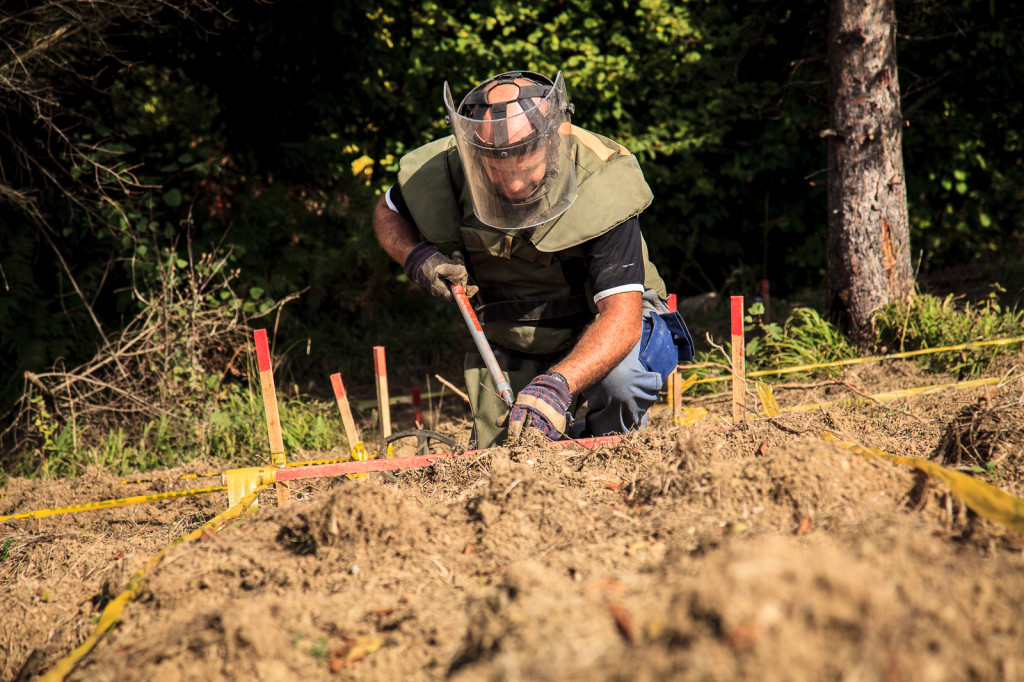 Goran Stanusic from Bosnia and Herzegovina Mine Action Center (BHMAC) clears a lot in an area near Visoko. Members of the mine squad work alone and scan about five square meters with a metal detector every 30 minutes.