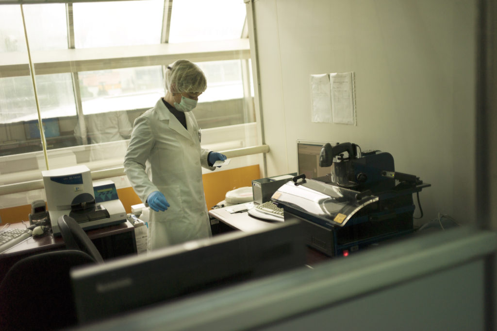 A lab technician prepared blood from living relatives for DNA matching. (Photo credit: Chris Bobyn)